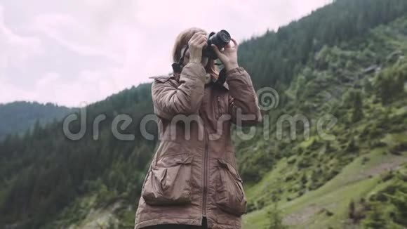 一个年轻的女徒步旅行者带着照片相机爬山罗马尼亚喀尔巴阡山脉视频的预览图