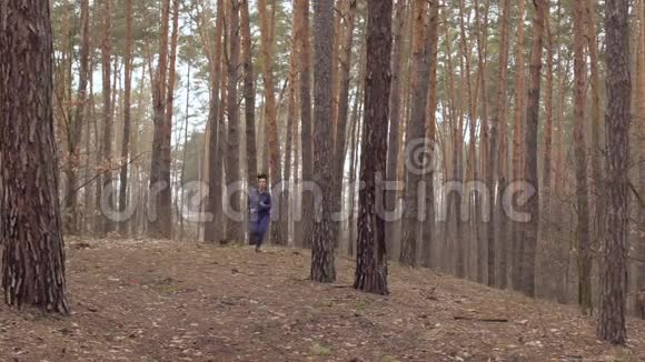 年轻漂亮的女人正在森林里奔跑视频的预览图