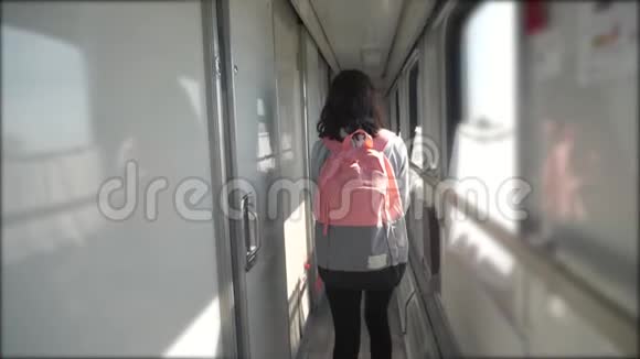 十几岁的女孩走在火车车厢里带着生活方式和背包旅游运输铁路概念小可爱视频的预览图