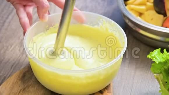 将自制蛋黄酱用搅拌机在塑料碗中搅拌视频的预览图