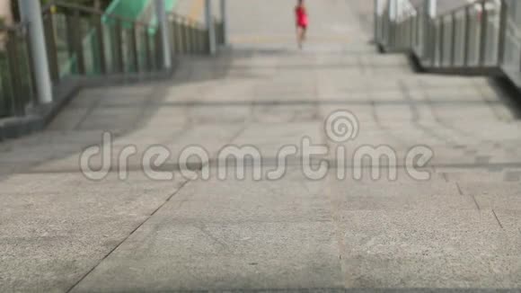 女人跑上城市楼梯视频的预览图