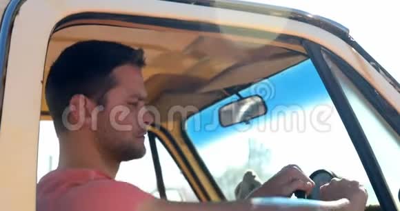 阳光明媚的一天男人坐在车里视频的预览图