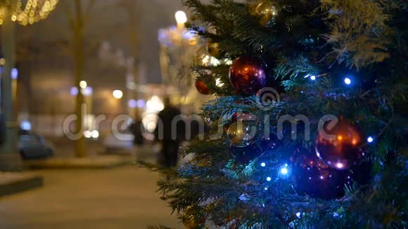 圣诞装饰球挂在树上的背景灯花环上视频的预览图