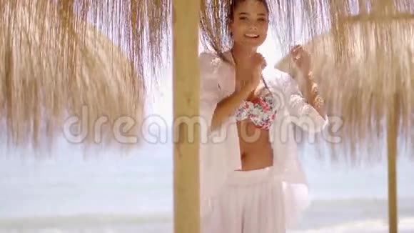 穿比基尼的女人在沙滩上打伞视频的预览图