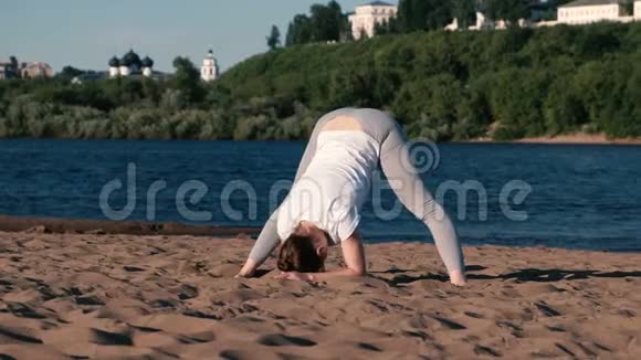 女人在城市河边的海滩上伸展瑜伽美丽的景色视频的预览图
