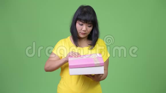 美丽快乐的亚洲女人打开礼品盒视频的预览图
