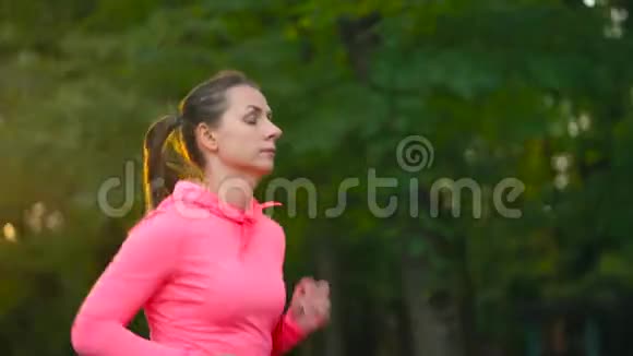日落时分一个女人穿过一个秋天的公园慢动作视频的预览图