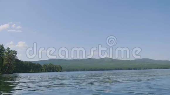美丽的蓝色清澈的水在湖岸海岸的森林景观水中倒影视频的预览图