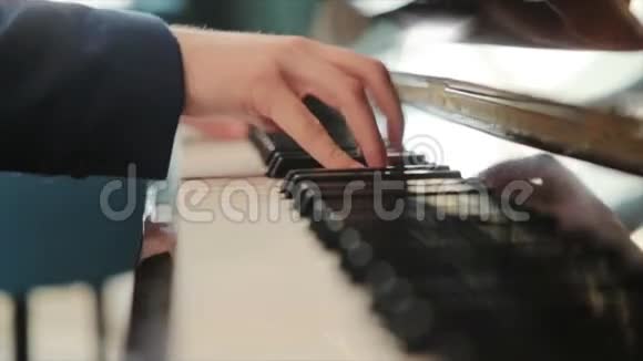 穿着蓝色西装的钢琴家在钢琴上弹得很快视频的预览图