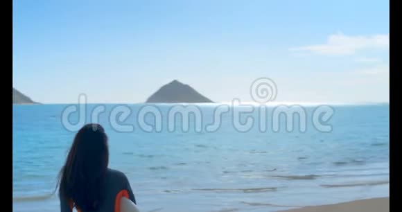 女冲浪者与冲浪板站在海滩4k视频的预览图
