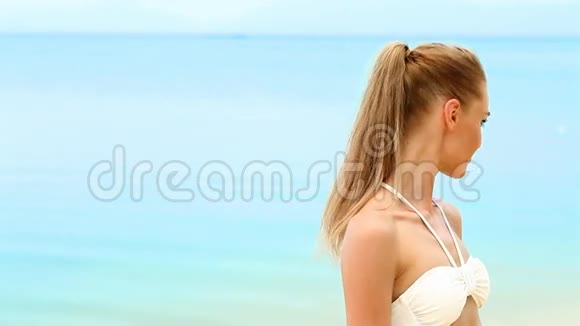 穿着白色比基尼的女人在海滩上放松视频的预览图