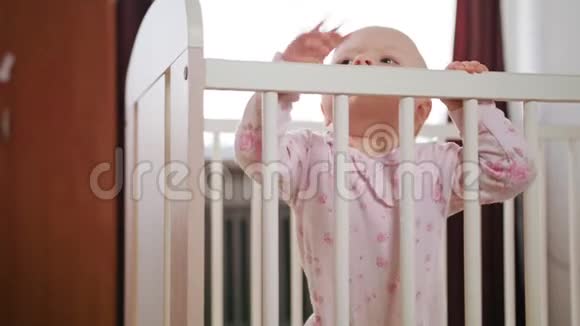 婴儿站在家里的婴儿床上视频的预览图