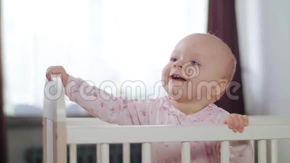 婴儿站在家里的婴儿床上视频的预览图