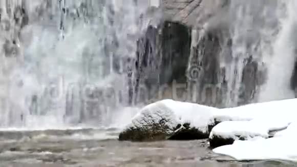 冬季瀑布小池塘和白雪皑皑的巨石瀑布层层叠叠山河的冰晶水和声音视频的预览图
