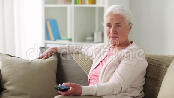 快乐的老年妇女在家看电视视频的预览图