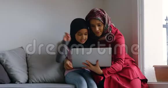 母亲和女儿在4k客厅用笔记本电脑视频的预览图