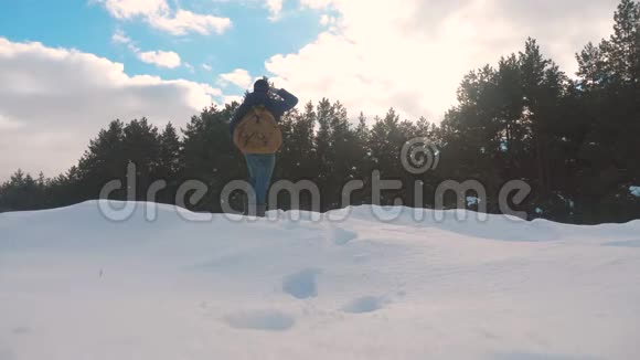 人的脚在深雪的冬天慢动作视频带背包生活方式的人在雪地森林里散步视频的预览图