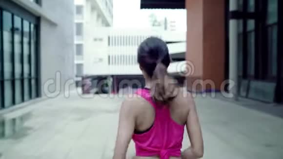 健康美丽的年轻亚洲跑步运动员穿着运动服在城市的街道上跑步和慢跑视频的预览图