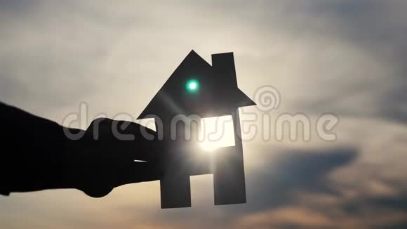 幸福家庭建设住宅理念生活方式男子手持纸房在夕阳下剪影视频的预览图