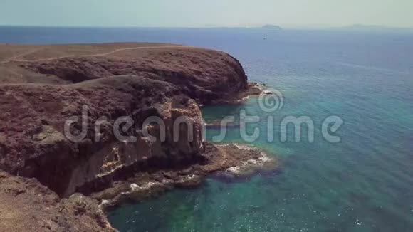 鸟瞰锯齿状的海岸和海滩兰萨罗特西班牙加那利道路和土路步行路线视频的预览图