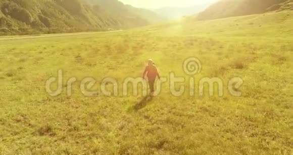 飞行背包徒步旅行游客走过青山野夏日的乡村山谷视频的预览图