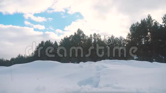 人的脚在深雪的冬天慢动作生活方式视频背着背包的人在雪地森林里散步视频的预览图