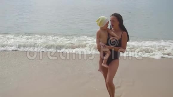 妈妈和一个两岁的女儿在沙滩上散步视频的预览图