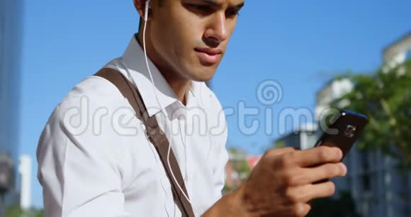 阳光明媚的一天男人用手机视频的预览图