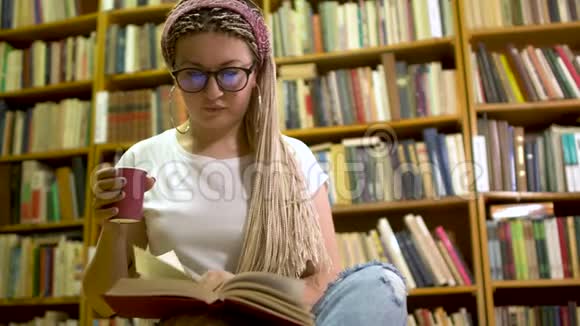漂亮的女孩在图书馆看书视频的预览图