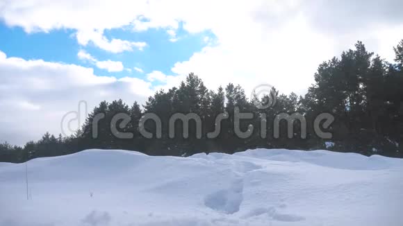 人的脚在深雪的冬天慢动作录像男人的生活方式旅行者带着背包在雪地森林里散步视频的预览图