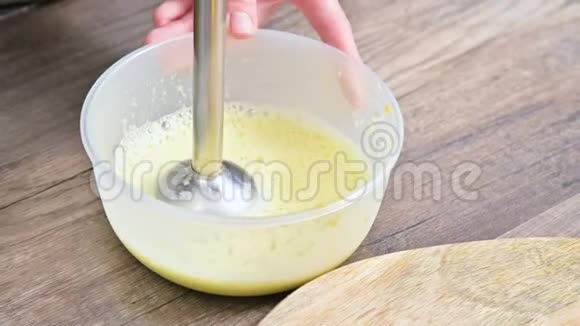 将自制蛋黄酱用搅拌机在塑料碗中搅拌视频的预览图