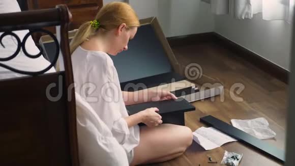 家庭主妇在家里组装家具使用手工工具组装电脑桌视频的预览图