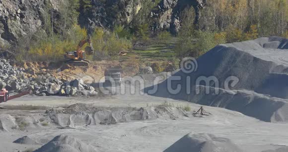一辆黄色装载的自卸卡车在采石场里一个采石场里的工作过程一个采石场里的一辆黄色自卸卡车视频的预览图