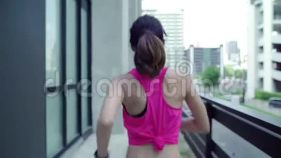健康美丽的年轻亚洲跑步运动员穿着运动服在城市的街道上跑步和慢跑视频的预览图