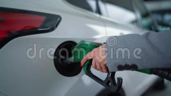 在加油站的一个特写镜头里女人往车里灌汽油视频的预览图