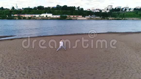 女人在城市河边的海滩上做瑜伽美丽的景色视频的预览图