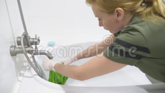 女家庭主妇在她家的浴室里打扫卫生视频的预览图