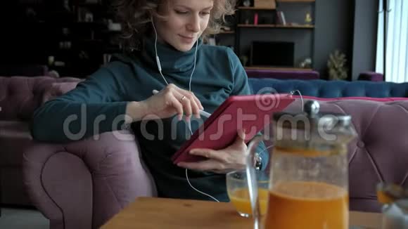 咖啡馆里有平板电脑的迷人年轻女性自由职业者的概念视频的预览图