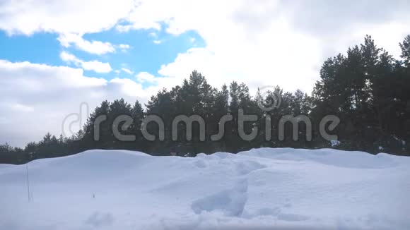 人的脚在深雪的冬天慢动作视频生活方式背着背包的人在雪地森林里散步视频的预览图