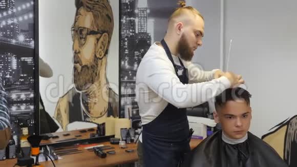 男士美容师理发店一个年轻人的头发护理理发师为一个发型工作视频的预览图