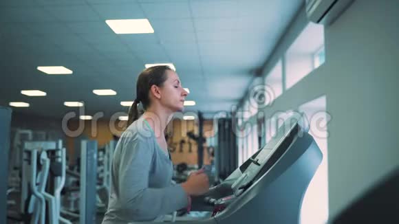 在健身房跑步机上跑步的女人视频的预览图