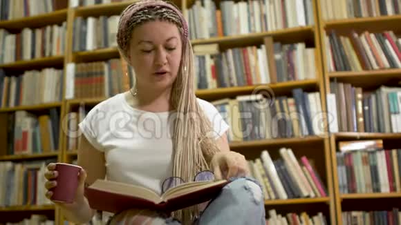 漂亮的女孩在图书馆看书视频的预览图
