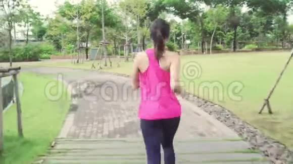 健康美丽的年轻亚洲跑步运动员穿着运动服在城市公园的街道上跑步和慢跑视频的预览图