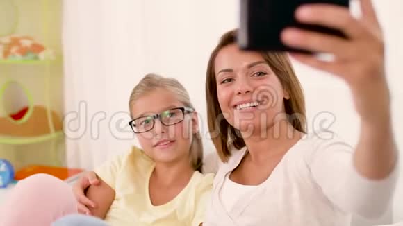 幸福的家庭在家里用智能手机自拍视频的预览图