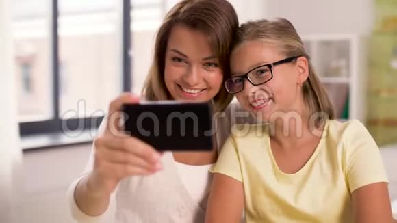 幸福的家庭在家里用智能手机自拍视频的预览图
