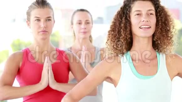 微笑着站在瑜伽位置的运动女性视频的预览图