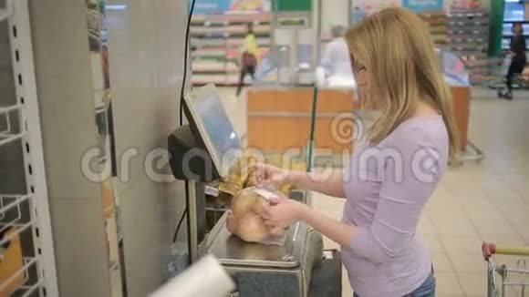 一个女人在超市的蔬菜货架上买蔬菜视频的预览图