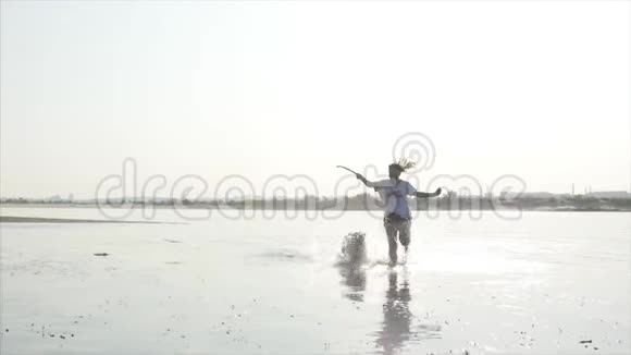 快乐而无忧无虑的童年孩子们和一只狗玩沿着沙子跑笑在河上玩推出一个玩具视频的预览图