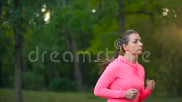 日落时分一个女人在秋天的公园里奔跑视频的预览图