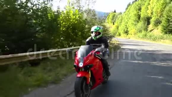 一个骑摩托车的人年轻的帅哥骑摩托车在山路上视频的预览图